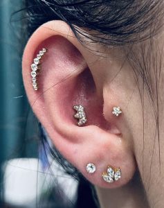 ausies auskarų vėrimo nuotrauka su helix ir conch papuošalais
