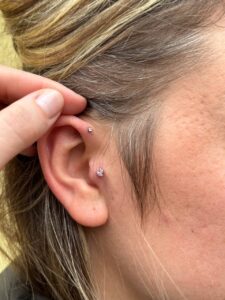 ausies auskarų vėrimo nuotrauka su keliais helix ir tragus auskarais